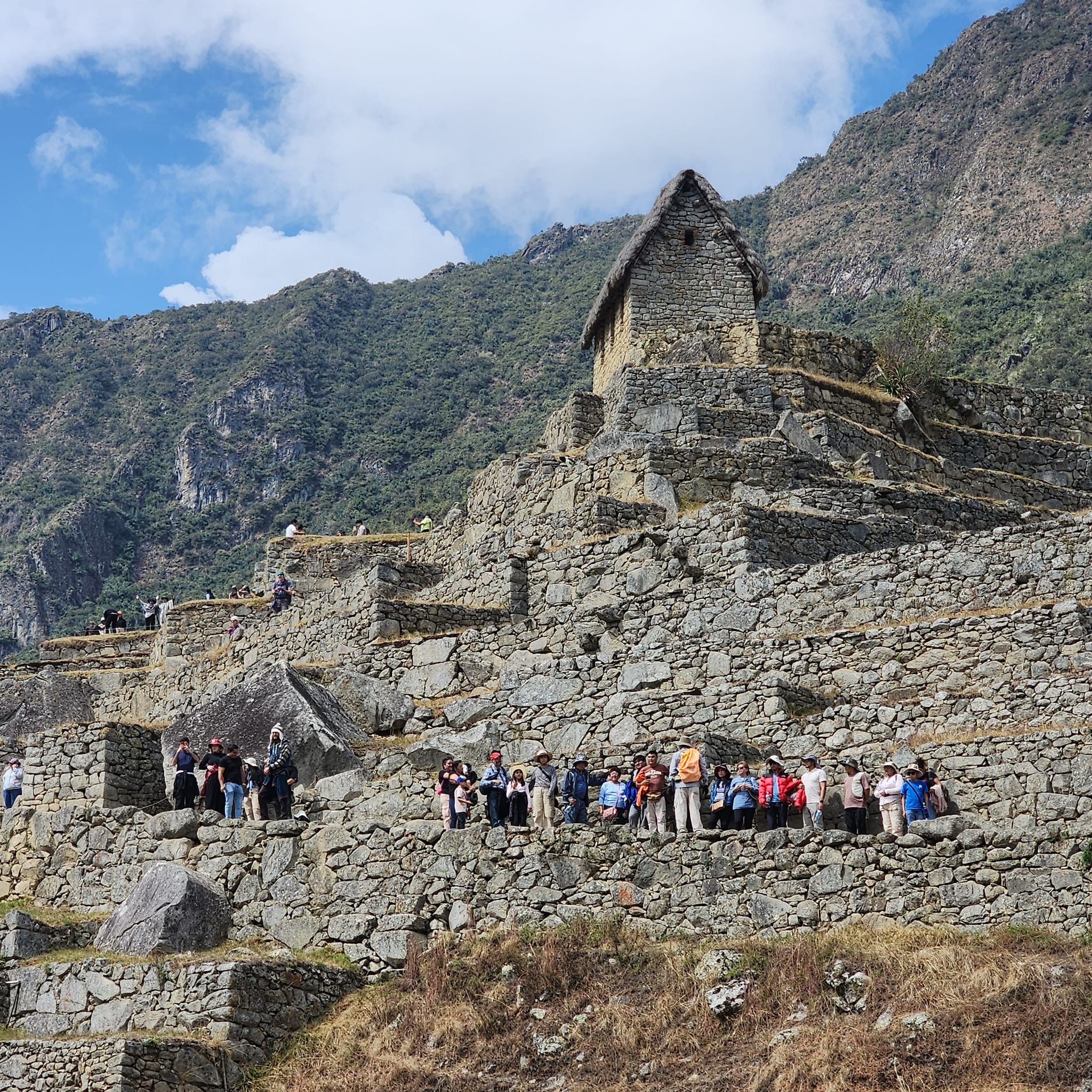 students standing in front of ancient ruins by mountain