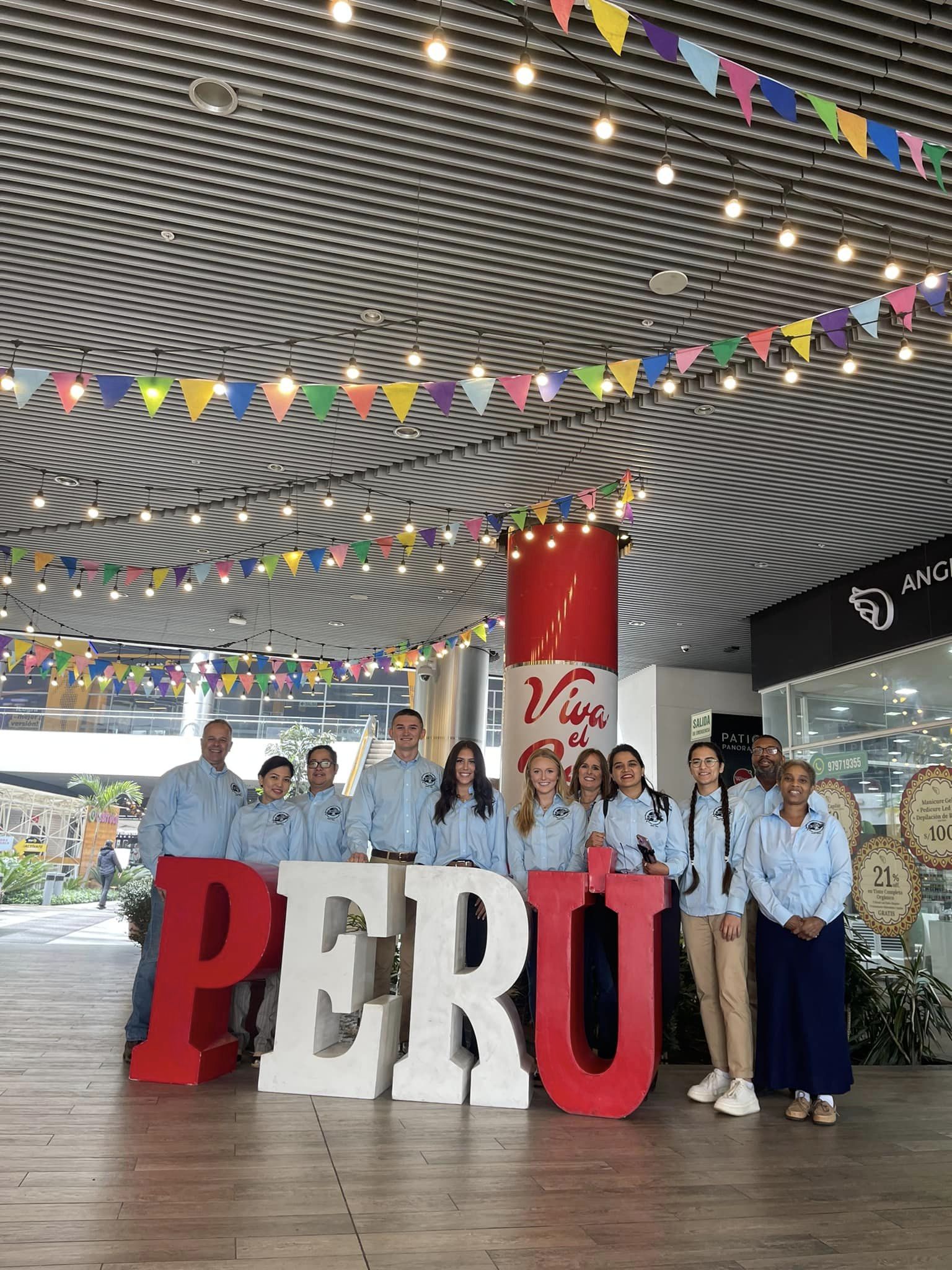 students standing behind big Peru letters