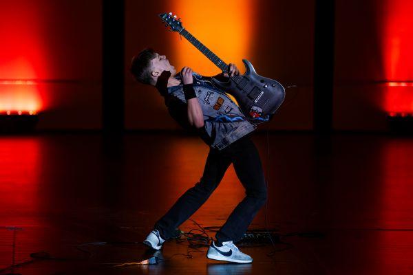 1 A student playing a guitar on stage