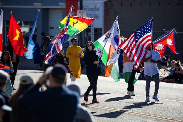 3 Students in a parade with assorted flags